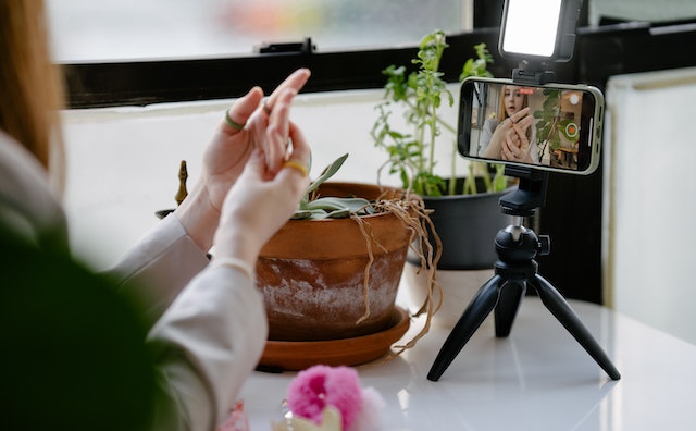 Een TikToker die een video opneemt voor TikTok van zichzelf en haar hand.