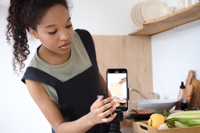 An influencer setting up her smartphone to start recording a video.