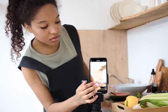 Een influencer die haar smartphone instelt om een video op te nemen.