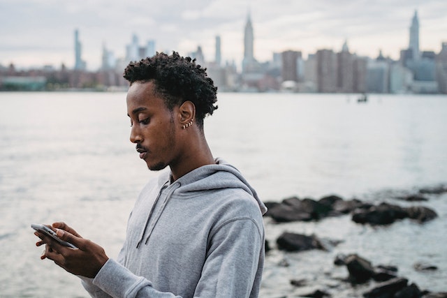 Een mannelijke influencer bewerkt een onderschrift op TikTok met zijn telefoon.