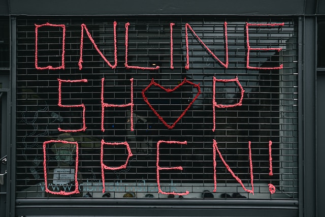 Schild an einem Schaufenster mit der Aufschrift "Online Shop geöffnet".