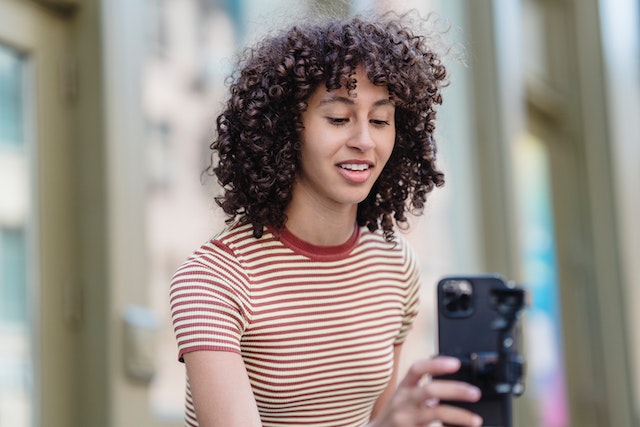 A young influencer filming herself on the street.