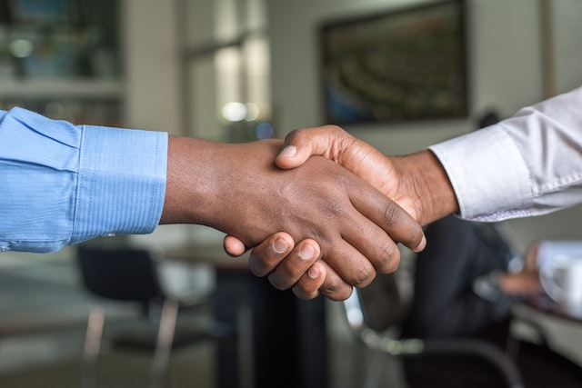 Two people shake hands to close a deal.
