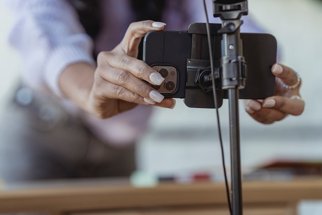 A TikTok influencer setting up a digital camera to start filming.
