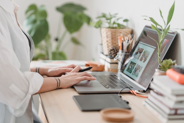 A woman sorts through photos on her laptop for a slideshow. 