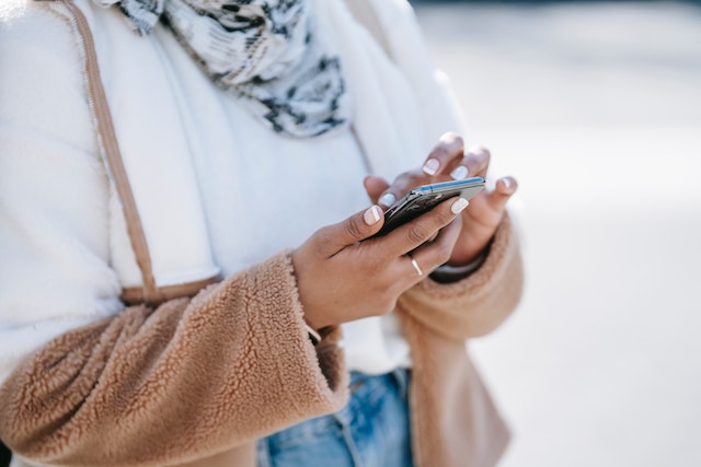 An influencer searching for TikTok downloader apps on her phone.