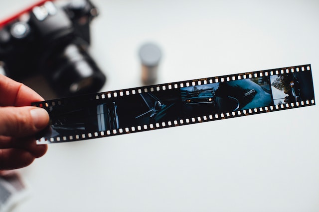 A person holds a film strip in one hand.
