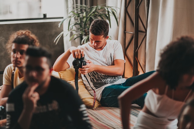 A man takes photos with his DSLR camera while attending a workshop.