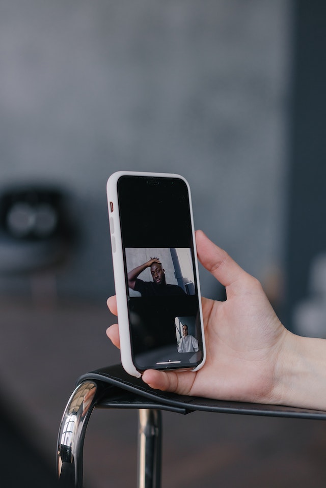  Een hand met een smartphone die een video opneemt voor TikTok.