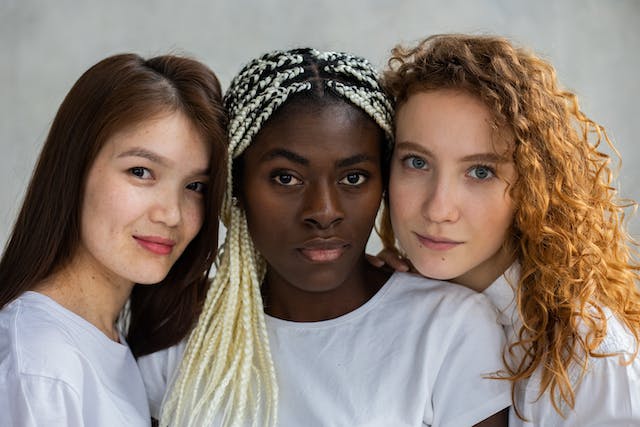 Une photo de trois femmes d'origines culturelles et de langues différentes. 