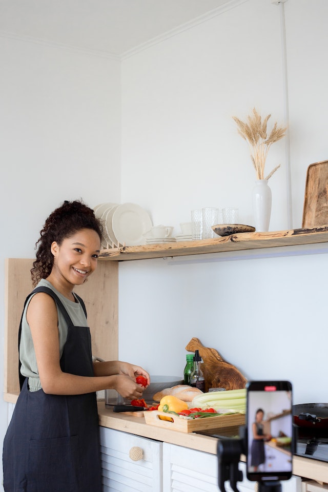 A girl cooking and recording a video for TikTok.