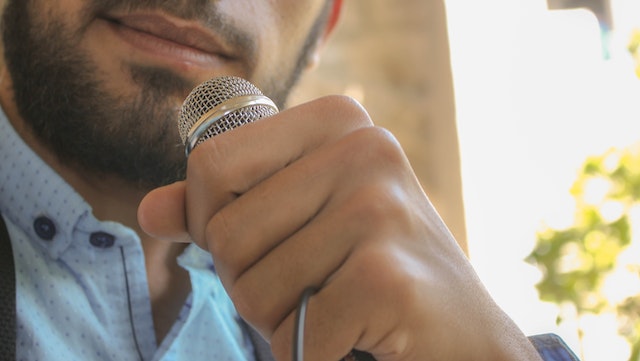 A man is holding a microphone and getting ready to speak.