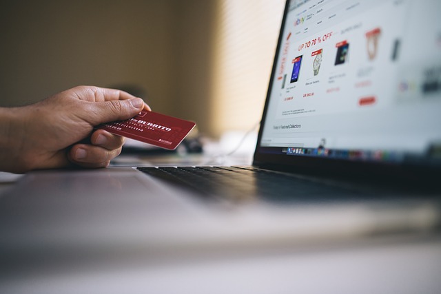 Uma imagem de uma pessoa fazendo um pagamento on-line com um cartão de débito.