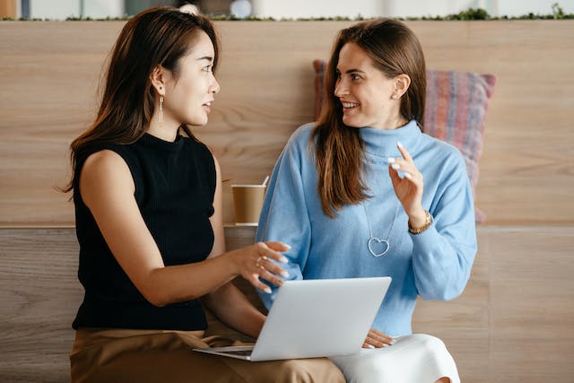 Een foto van twee vrouwelijke professionals in een levendig gesprek. 