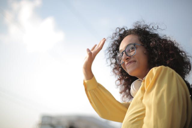 A woman waves goodbye. 