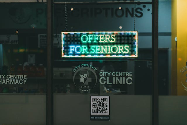 A clinic glass window displays a QR code and a lighted sign.