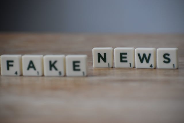 Black and white letter tiles spell “FAKE NEWS.”