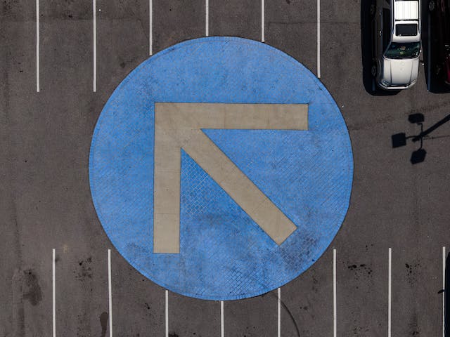 A photo of a gray arrow on a blue circle. 