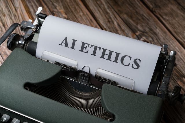 A typewriter with a piece of paper with the words “AI ETHICS” printed on it. 
