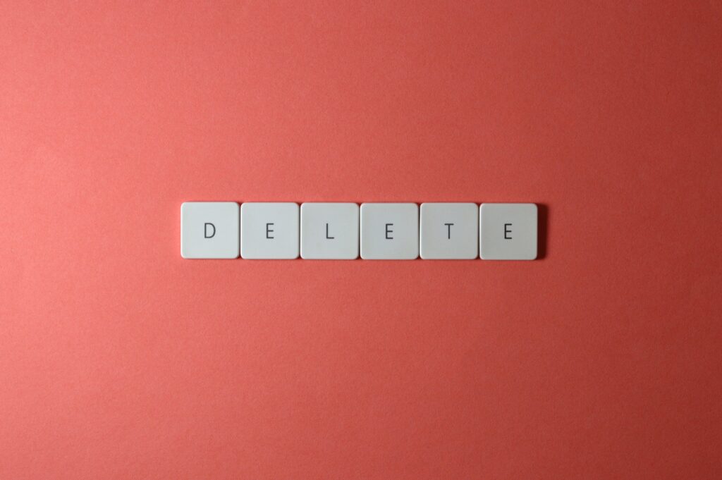 拼成 "DELETE "的白色字母瓷砖照片。