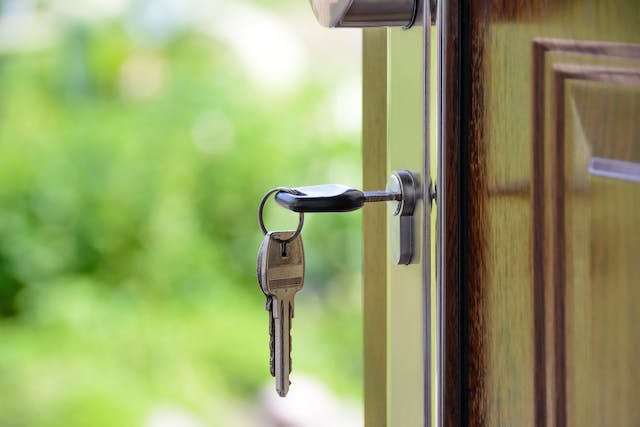 A close-up shot of a door with a key in the lock. 