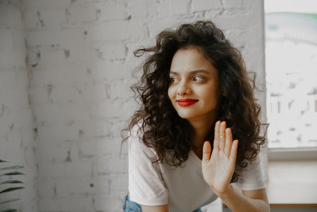 A woman waves goodbye. 