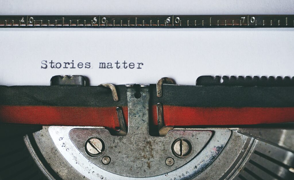A photo of a piece of paper in a typewriter with the words “Stories matter” printed. 
