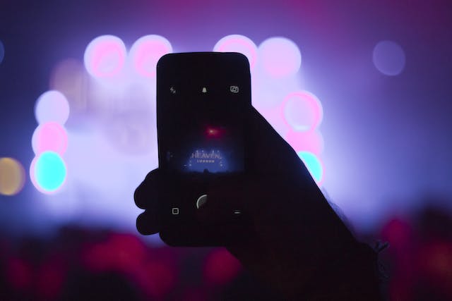 A person broadcasts a concert LIVE using their phone. 