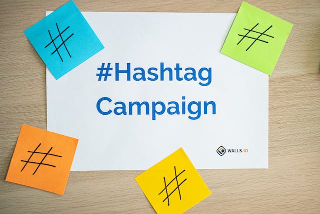 Post-its with the hashtag sign printed on them surround a piece of paper printed with the words “Hashtag Campaign.”