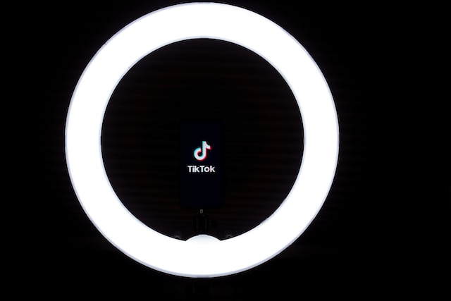 A picture of a ring light for video enhancement illuminating the word TikTok and the app’s logo.