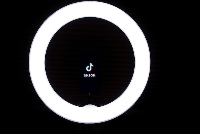 A picture of the TikTok logo in the middle of a black and white round ring light.