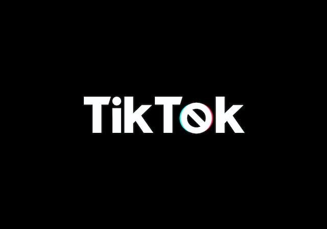 O imagine a cuvântului "TikTok" imprimată în alb pe un fundal negru.