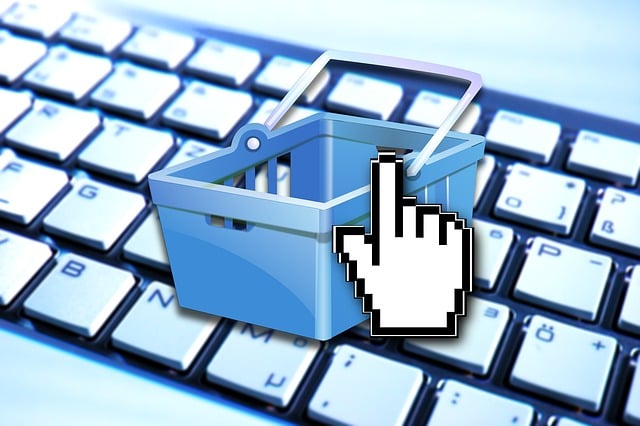 An illustration of a shopping cart over a keyboard depicting e-commerce trade.