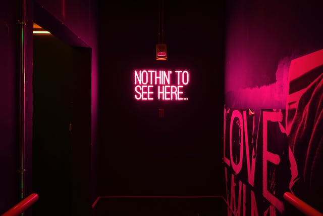A red neon sign says, “Nothin’ to see here.”