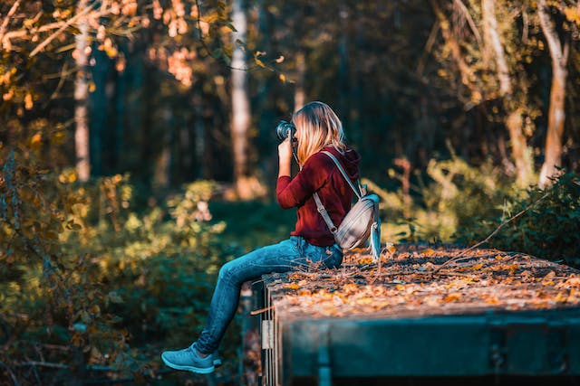 A woman takes nature photos with her DSLR camera. 