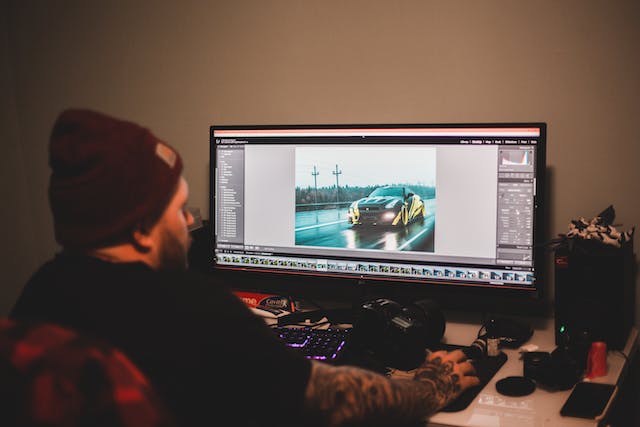 A man edits a video on his computer. 