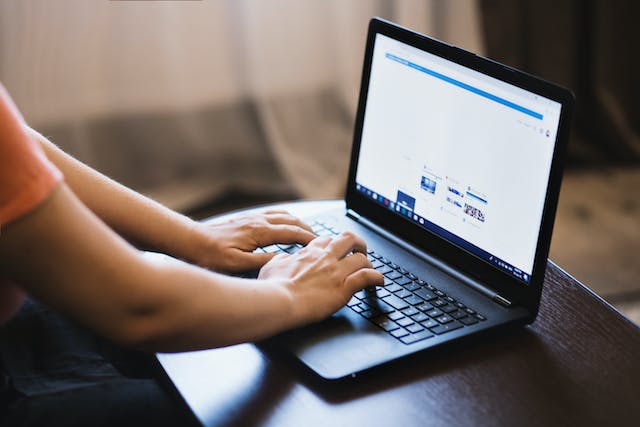 O imagine a unei persoane care efectuează o căutare pe internet pe laptop. 