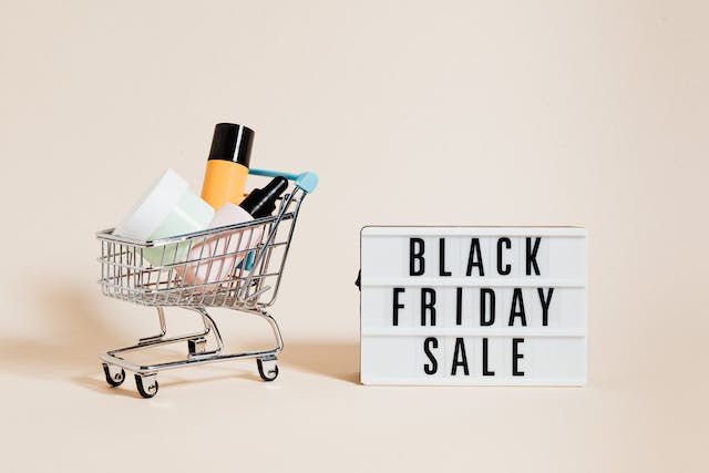 A photo of a Black Friday Sale sign beside a shopping cart. 
