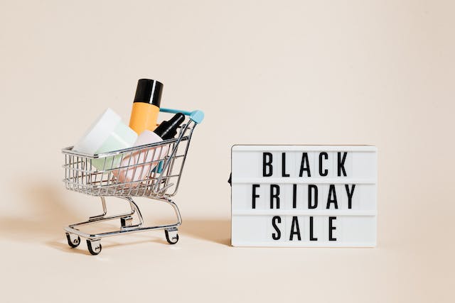 Een foto van een Black Friday Sale-bord naast een winkelwagentje. 