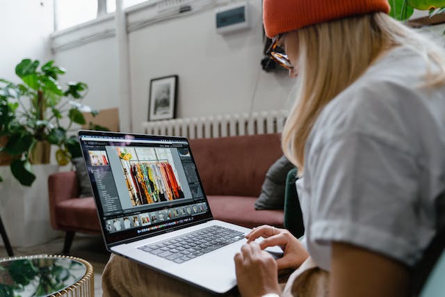 A woman sorts through images on her laptop.