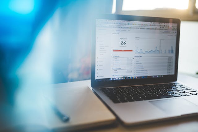 A picture of a laptop on a table displaying some graphs and information.