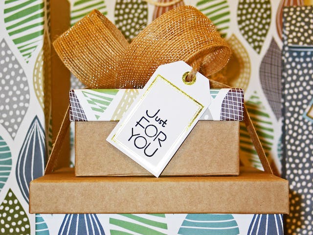 Uma imagem de uma pilha de quatro caixas de presente com um pequeno cartão que diz: "Just for you".