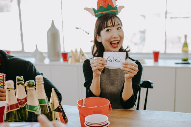 Una donna regge felicemente un foglio di carta con un nome. 