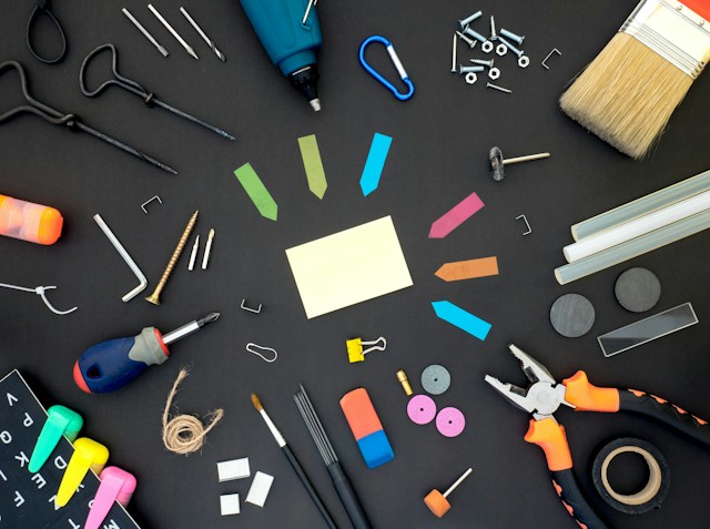 A circular arrangement of various tools on a black surface.