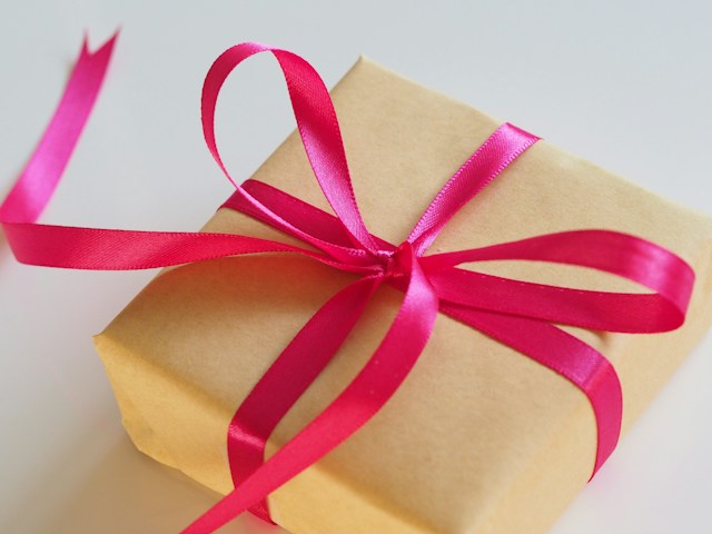 A brown gift box tied with a pink ribbon.