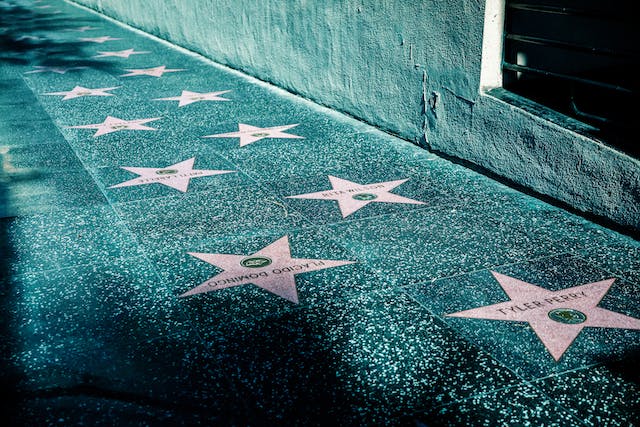 A photo of stars on a sidewalk with names of celebrities printed on them. 