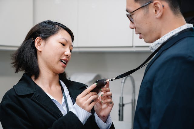 A woman checks a man’s ID card. 