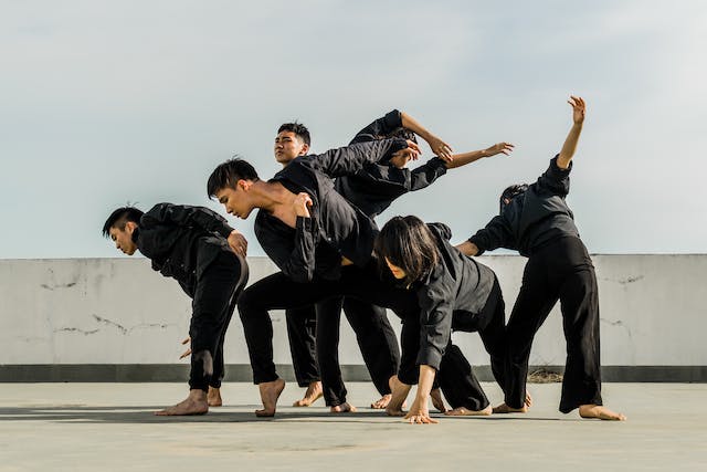 A group of people practices their dance on a rooftop. 