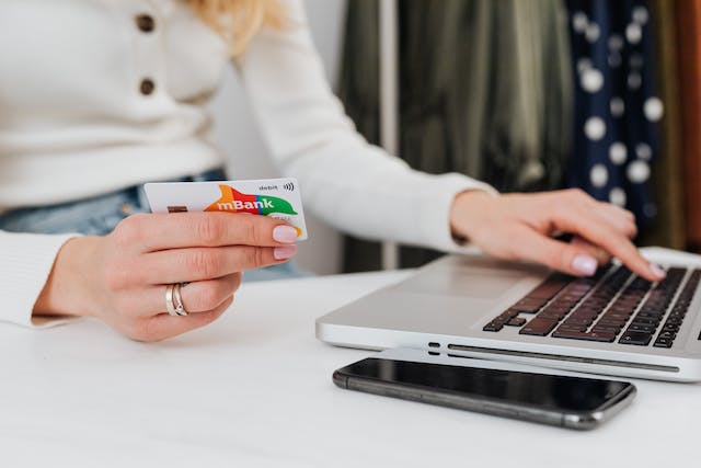 A lady using her debit card for an online transaction.