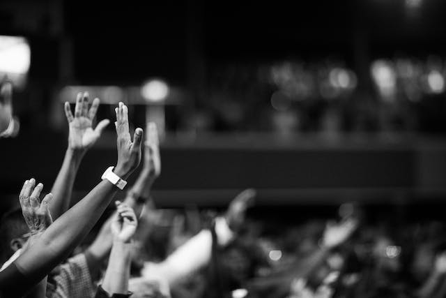 Uma imagem de pessoas levantando as mãos. 